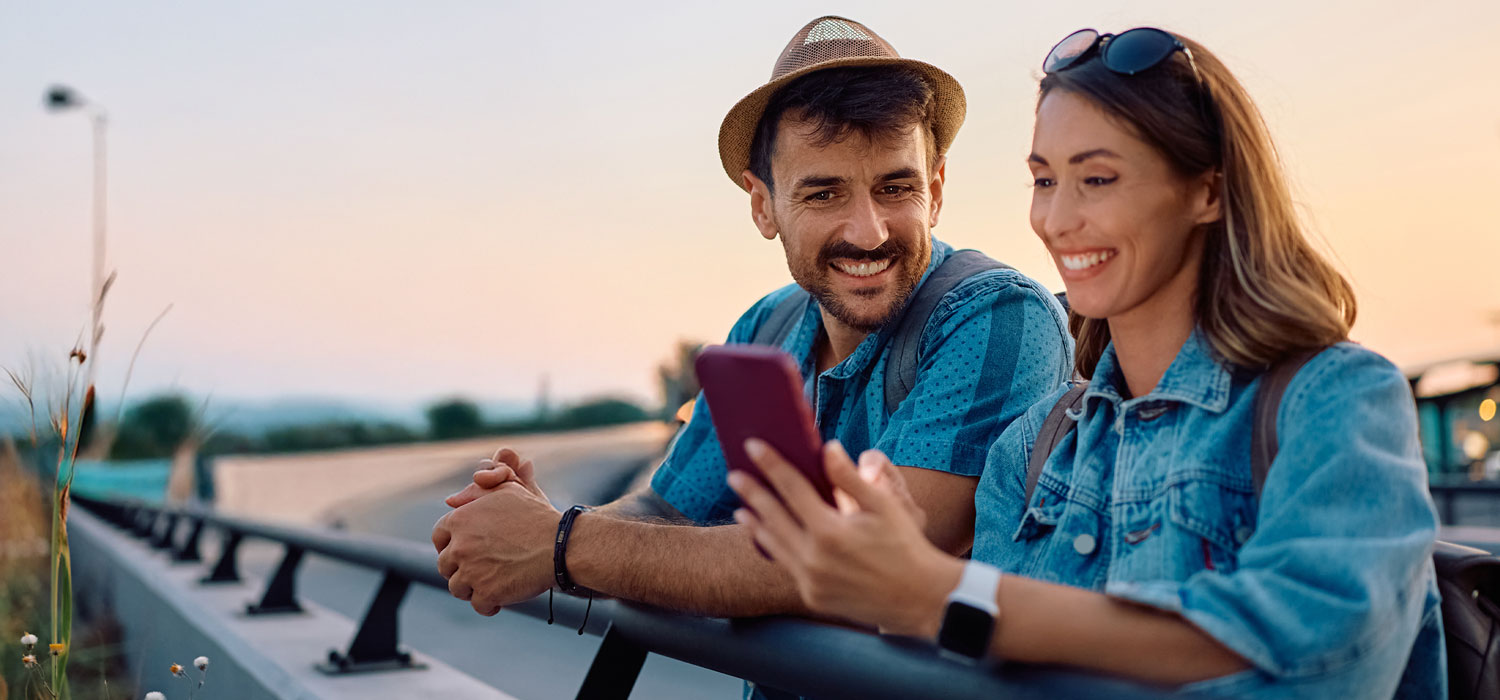 Casal olhando para um mapa a decidir qual o seu próximo destino de viagem